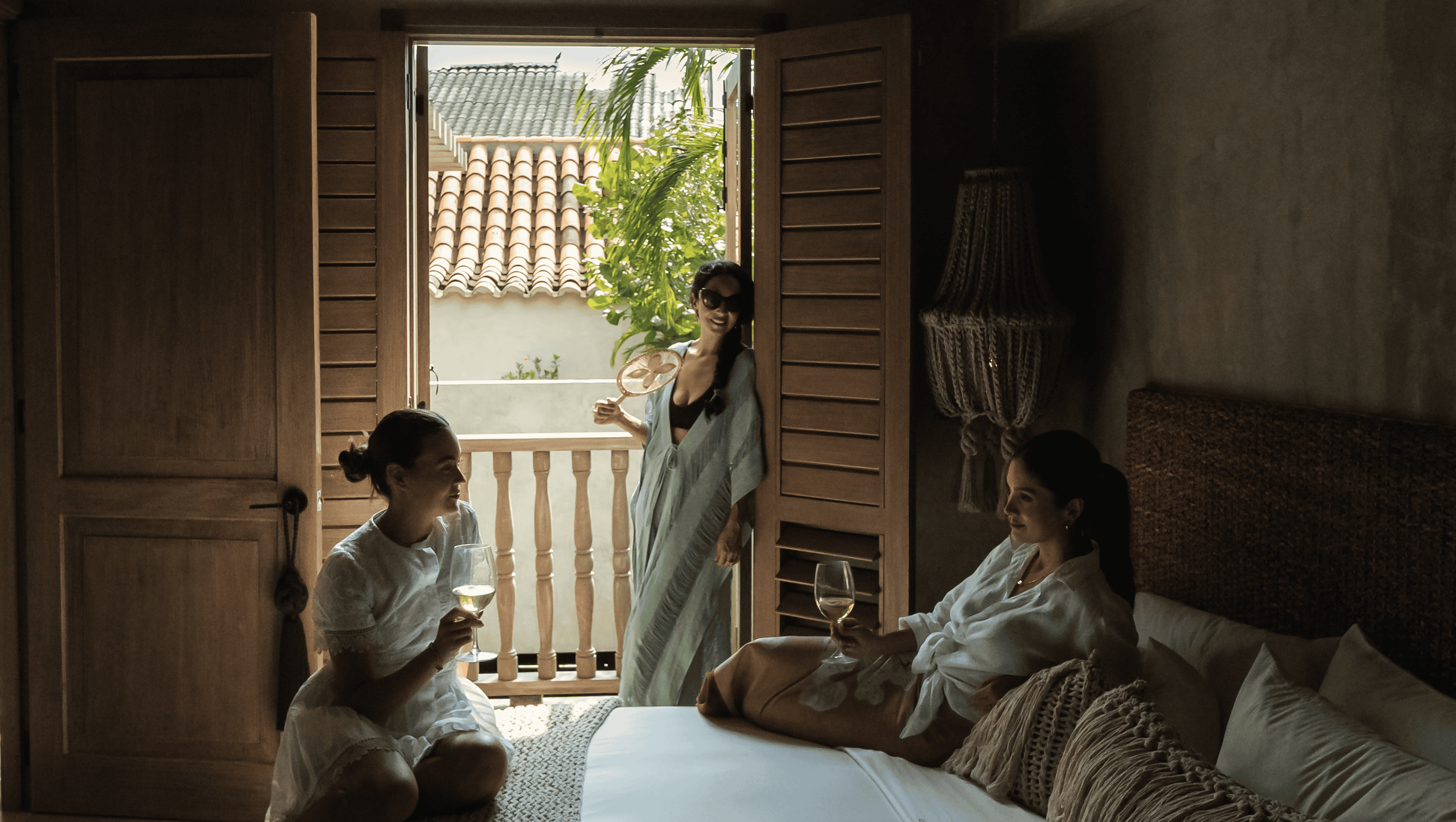 Women relaxing with drinks on a bedroom balcony at Butiq World.