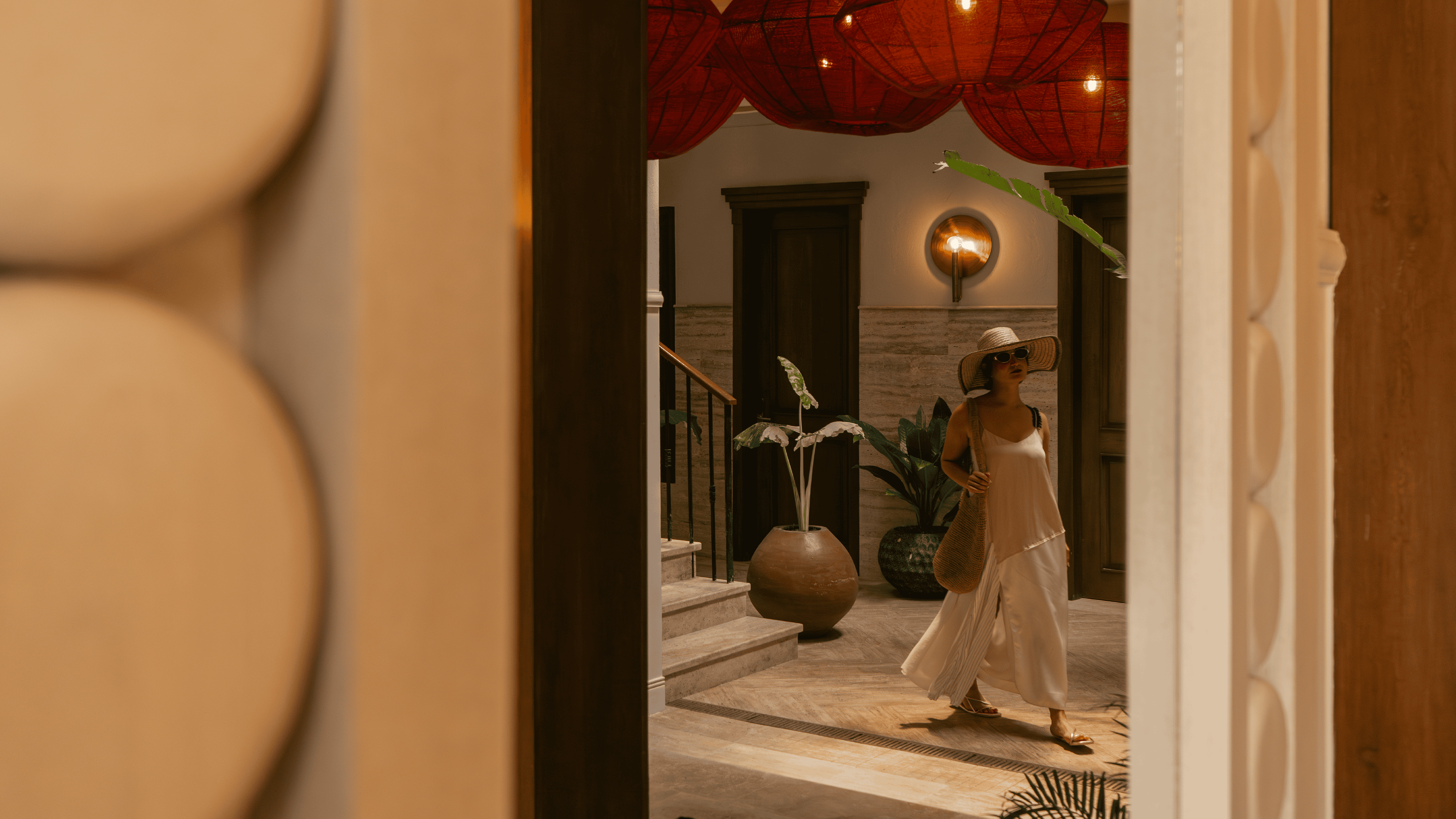 Woman in fashionable attire at Butiq World boutique entrance, stylish shopping experience.