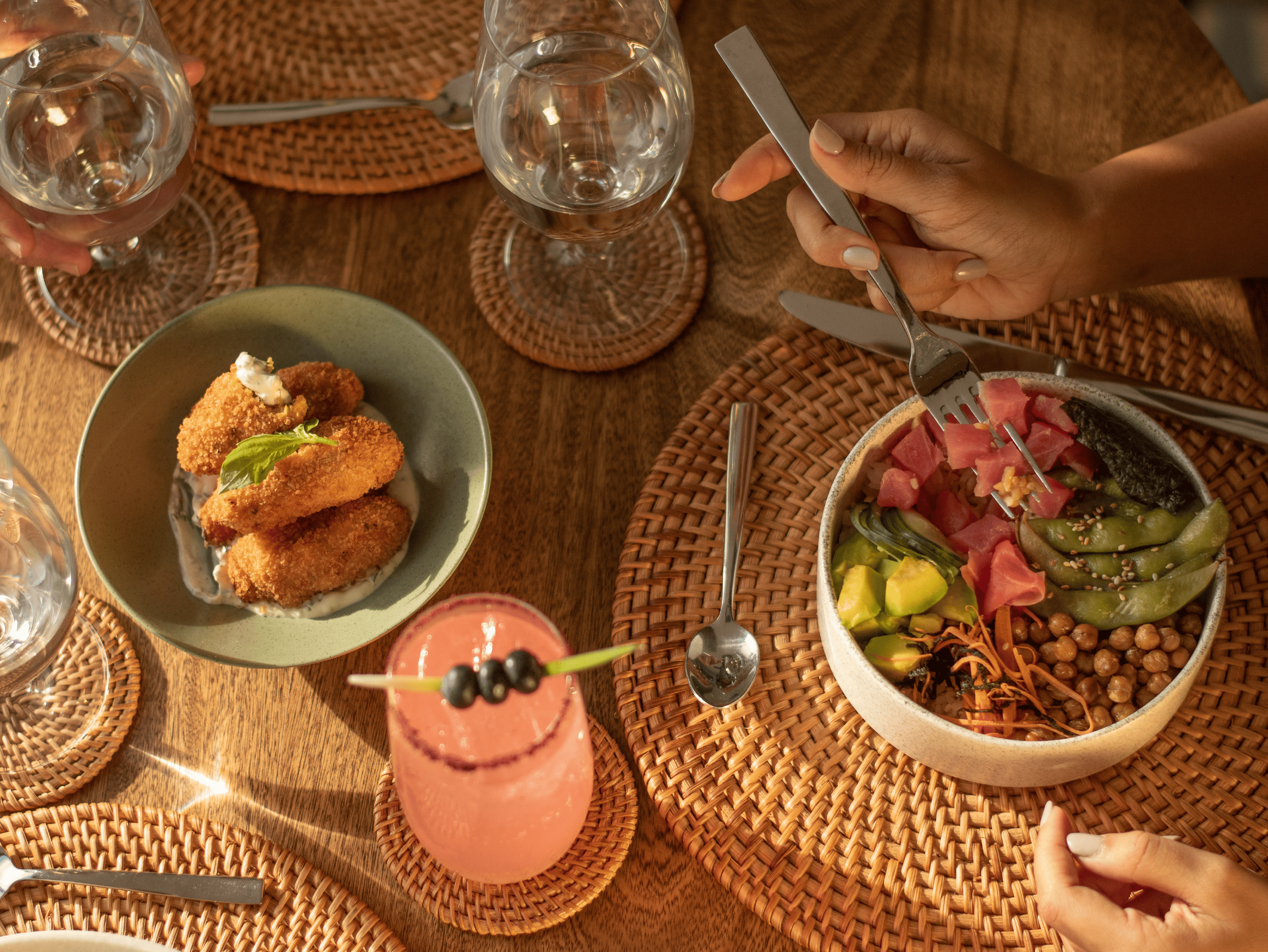 Mediterranean salad with chickpeas, pickles, and fresh vegetables served on a woven placemat.