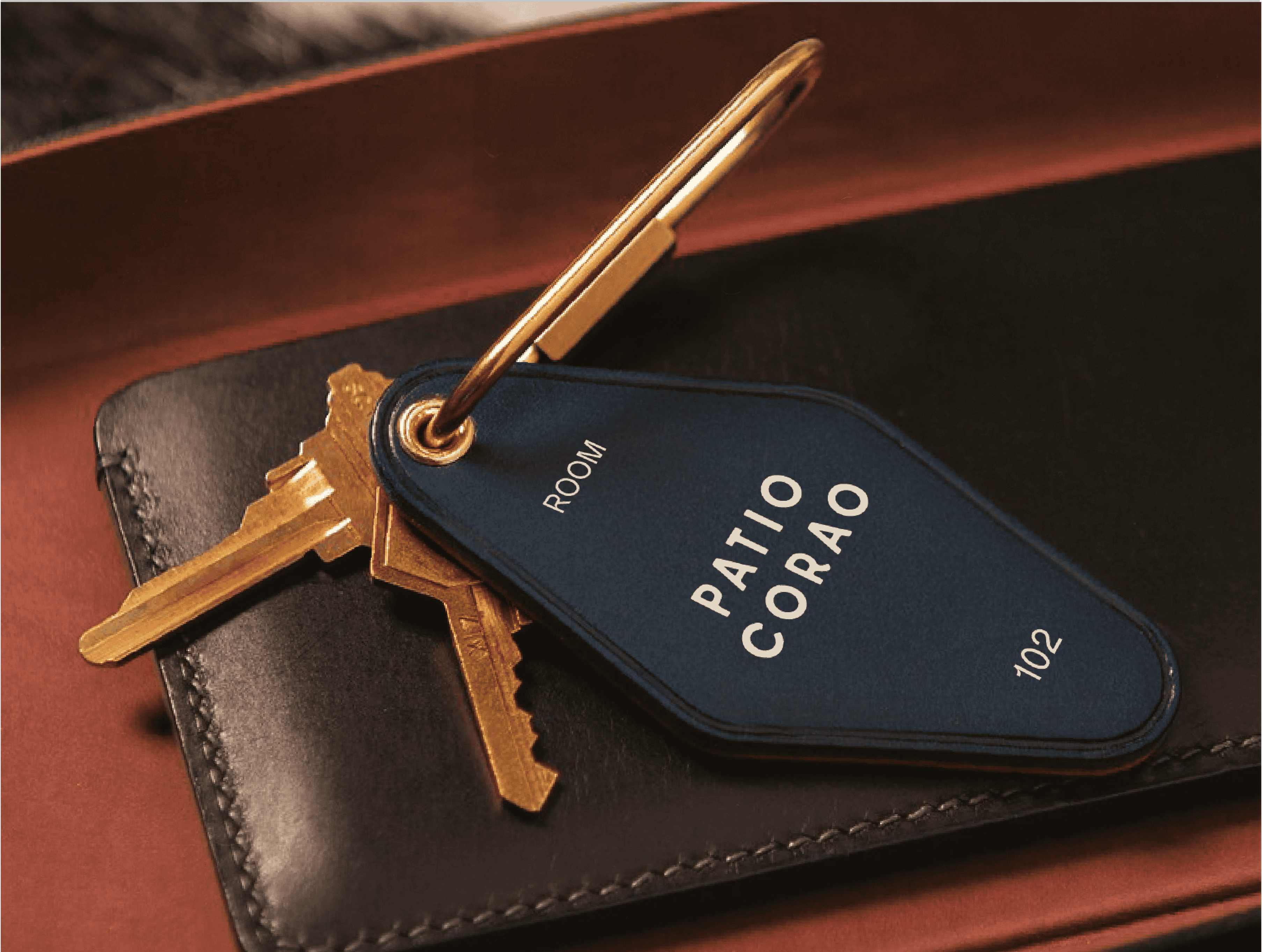 Hotel room key with "Patio Corao" label and gold key attached to a leather keychain.