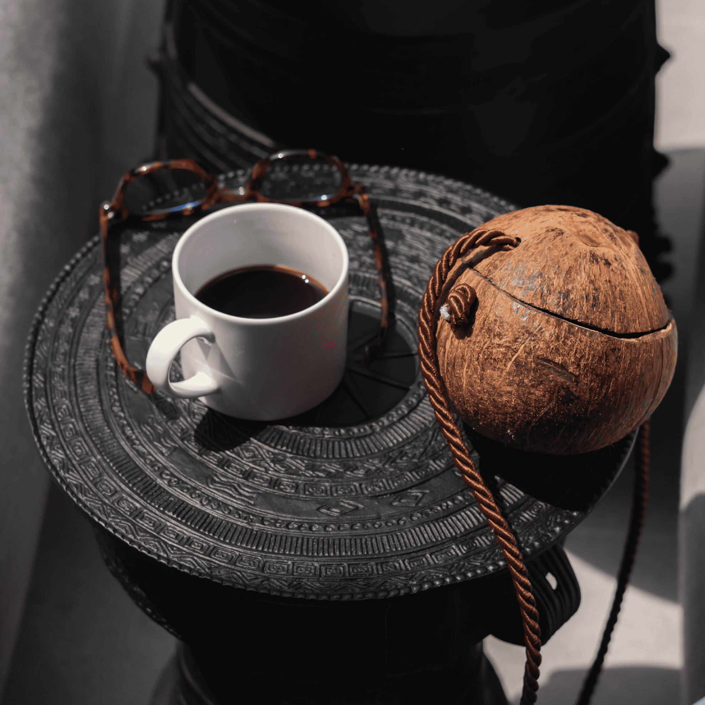 Coffee and coconut on a decorative tray with sunglasses, close-up shot.