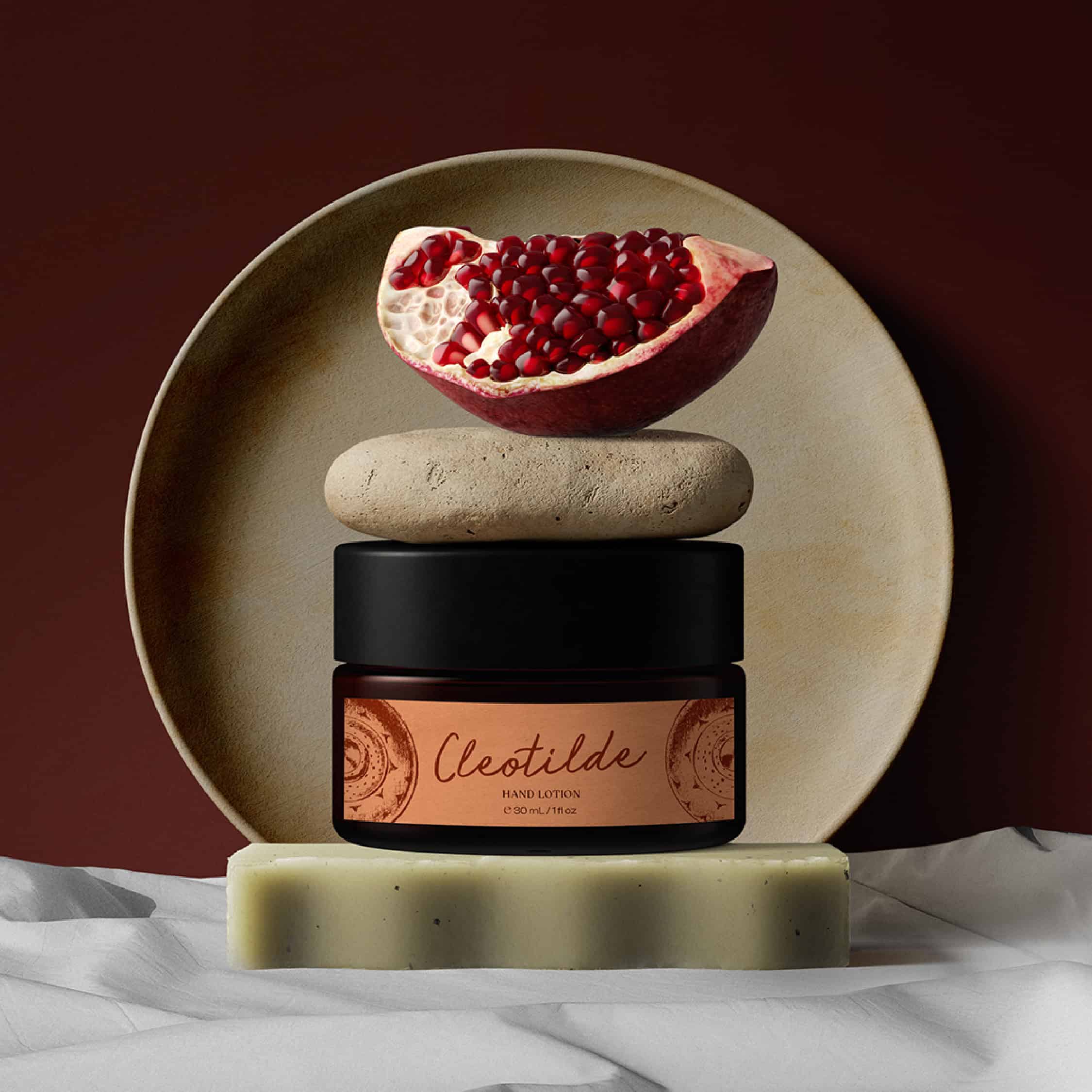 Luxury hand lotion with pomegranate extract in a sleek jar on decorative stones.