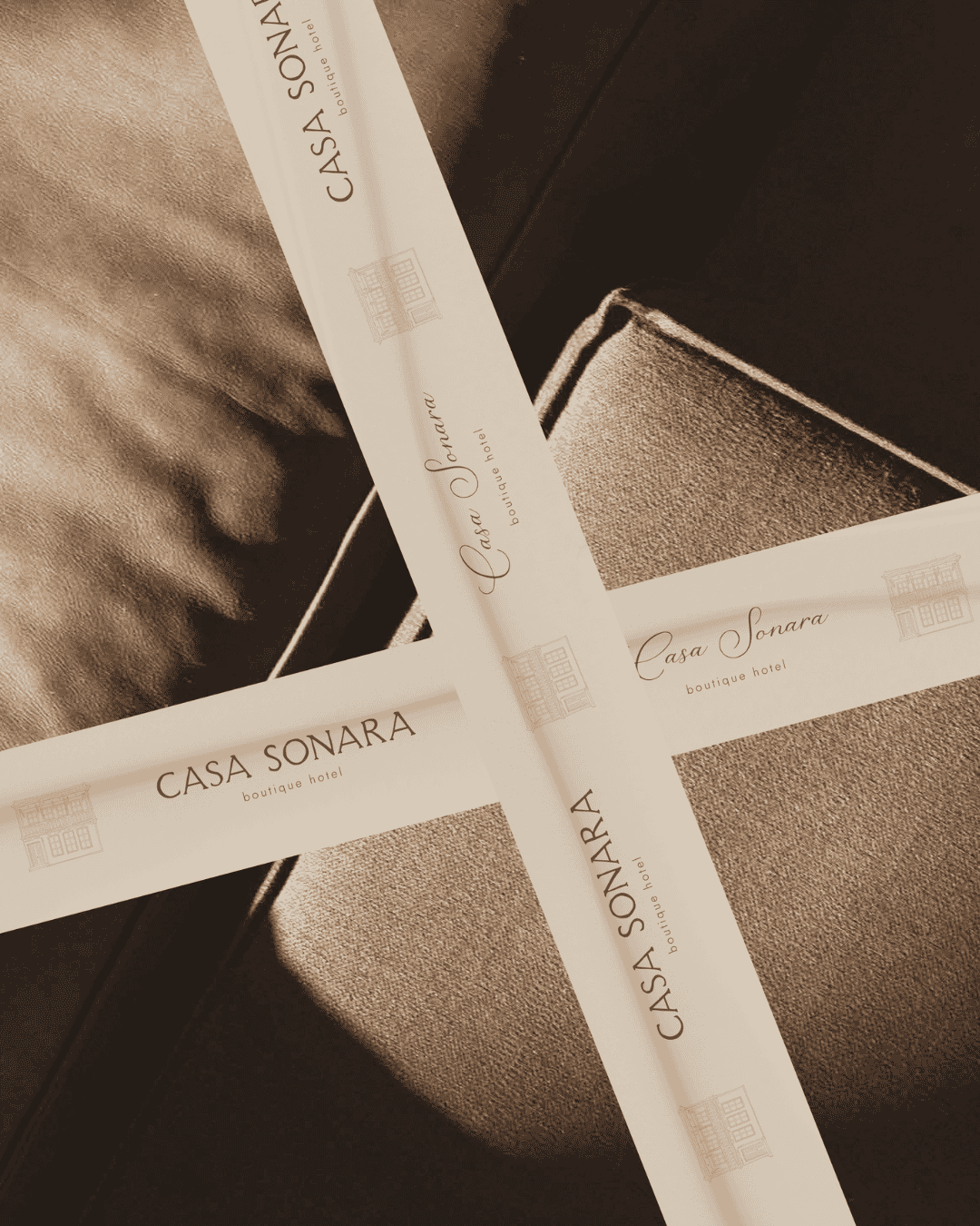 Elegant ribbon with Casa Sonara Boutique Hotel branding on a textured surface.