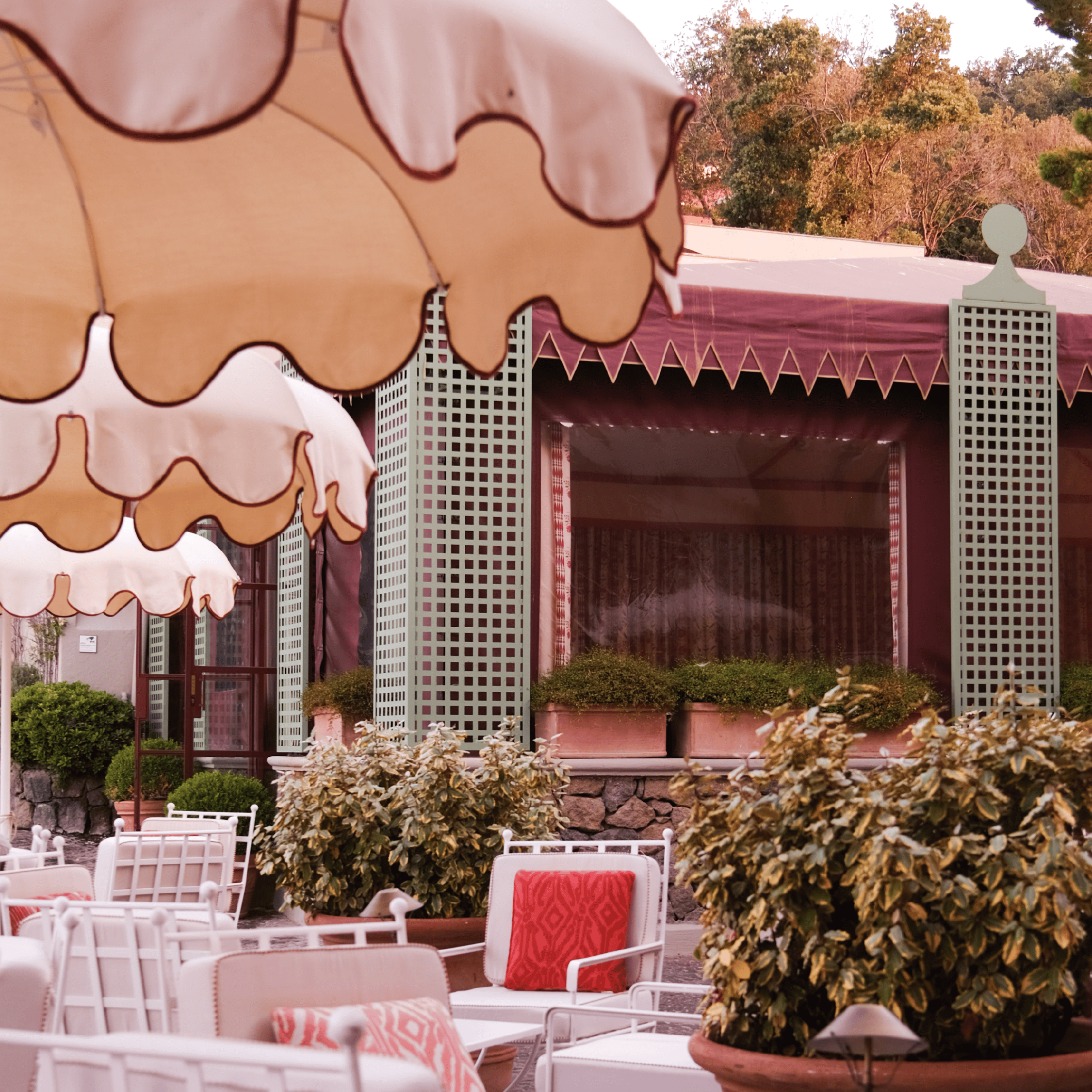 Outdoor lounge area with stylish seating and large umbrellas at Butiq World. Perfect for relaxing an.