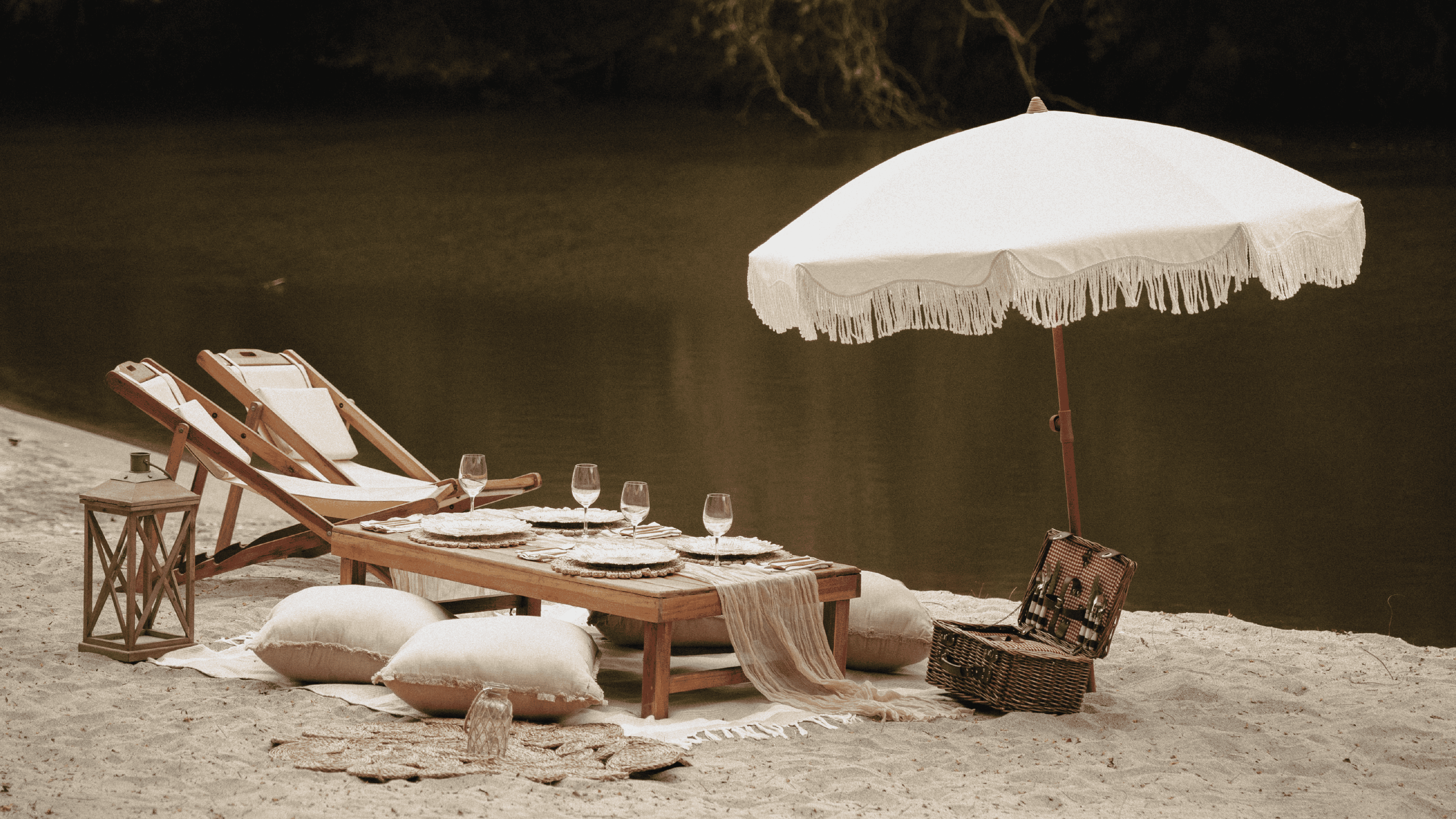 Charming outdoor setup featuring wooden sunbeds, a large white umbrella, and cozy cushions by the ri.