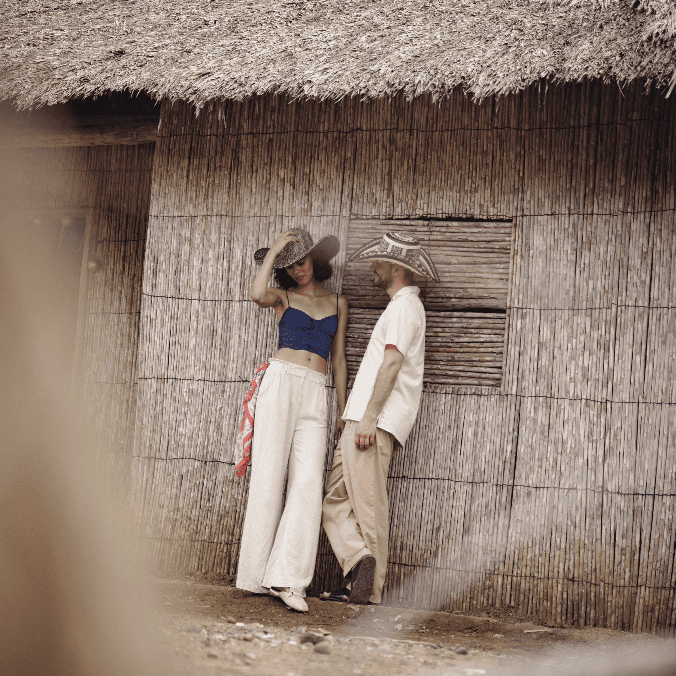 Elegant women in summer fashion standing outside a rustic hut, showcasing casual chic style with wid.