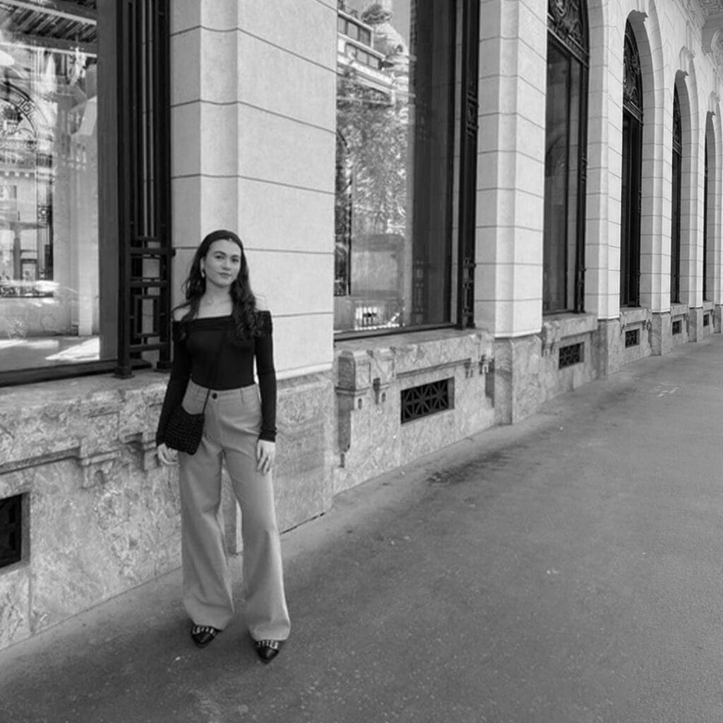 Stylish woman standing outside a historic building in an urban setting.
